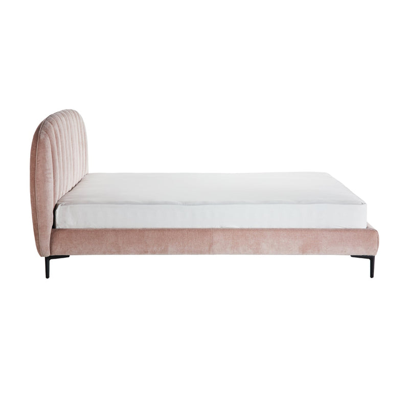 Pink upholstered bed with white mattress on a white background