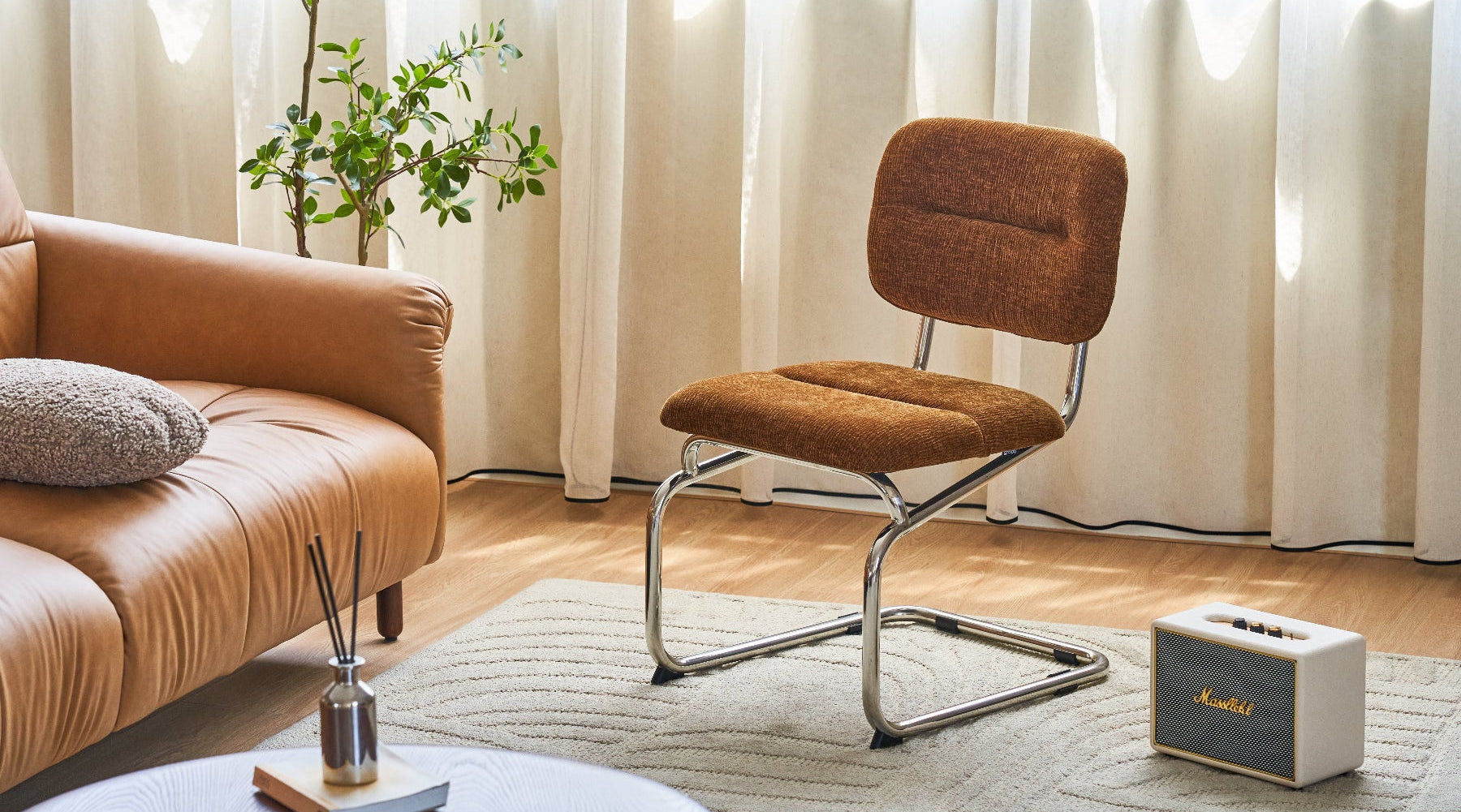 Brown chair and sofa in a living room with a plant and decor items.