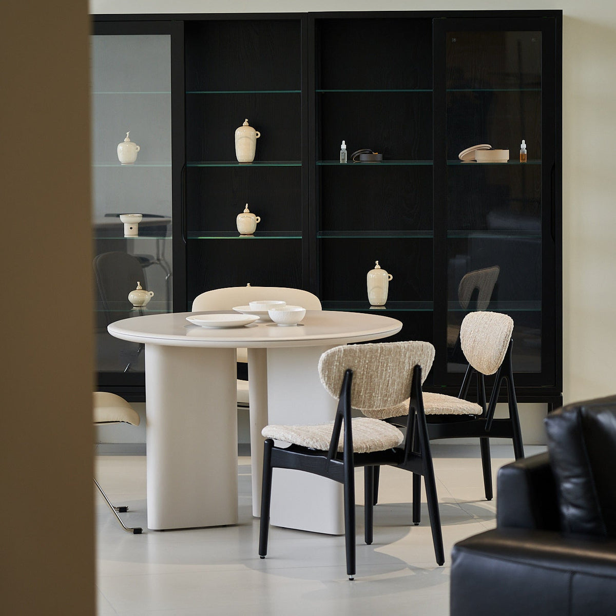 Modern dining area with a white oval table and chairs in a stylish interior setting.