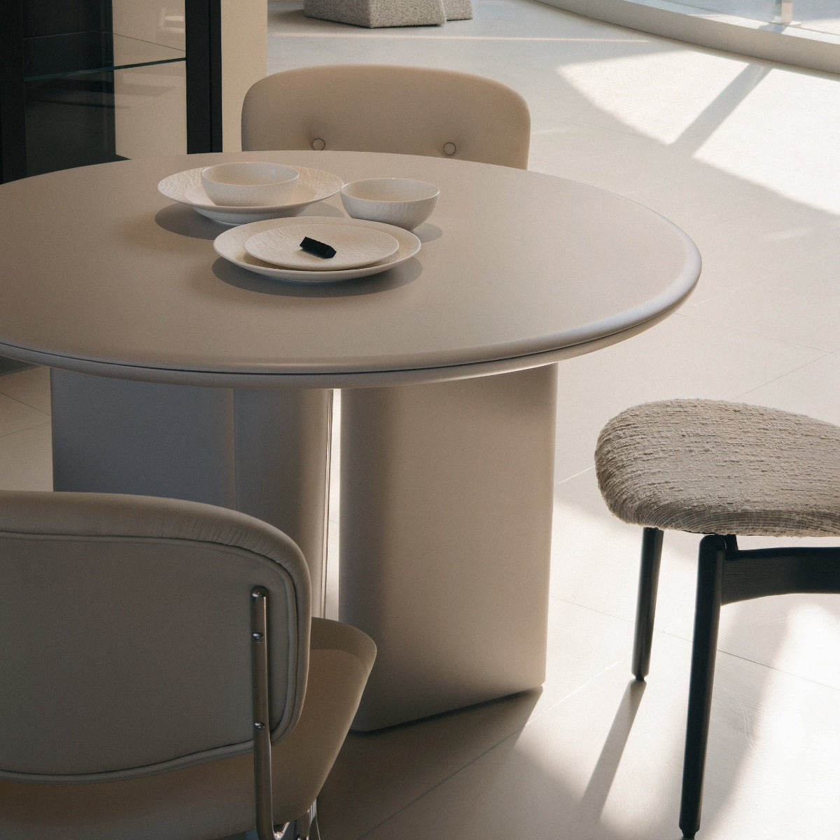 Modern dining area with a round table and chairs in a stylish interior setting.
