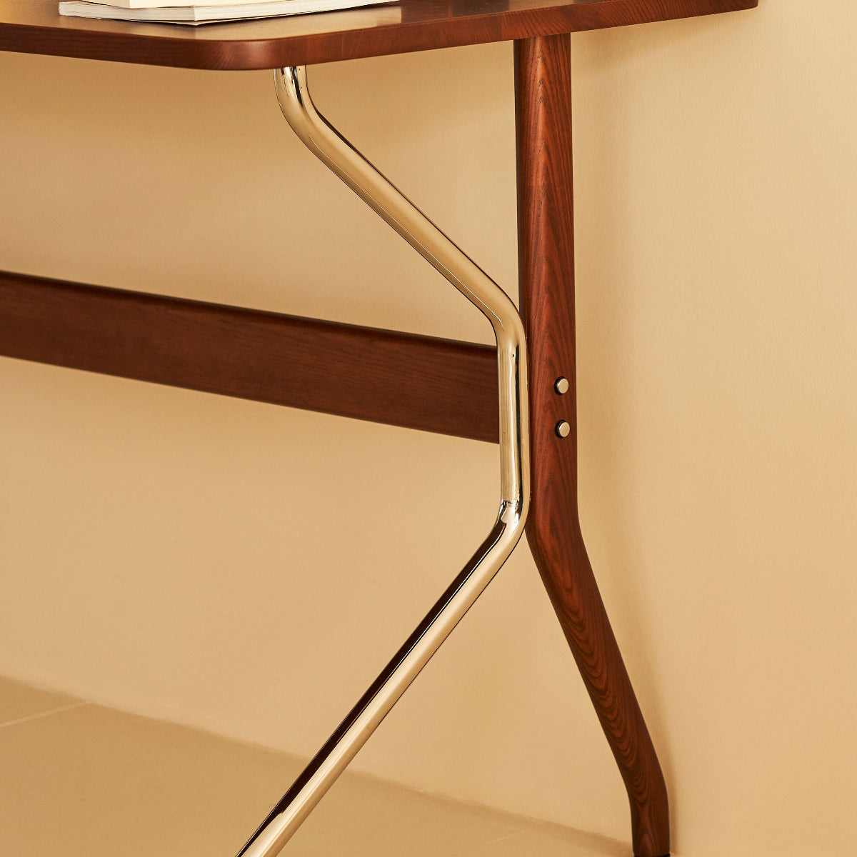 Wooden desk with metal legs against a beige wall