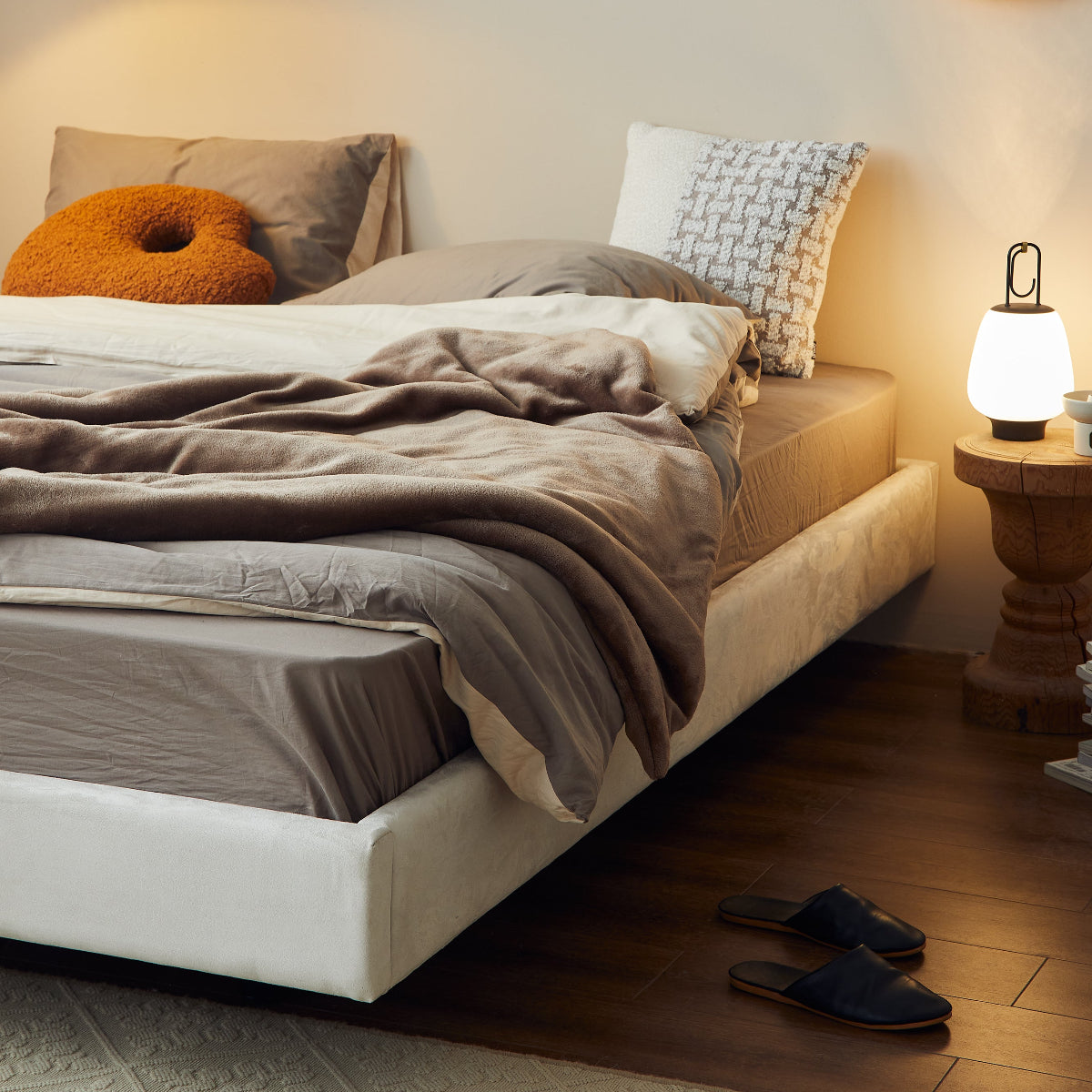 Neatly made bed with pillows and blankets in a bedroom setting.