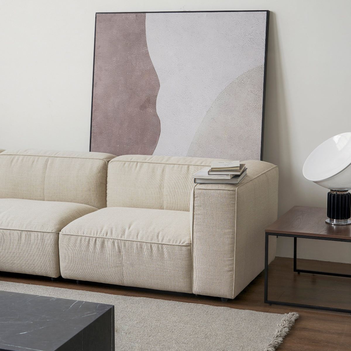 Beige sofa in a living room with a abstract painting on the wall