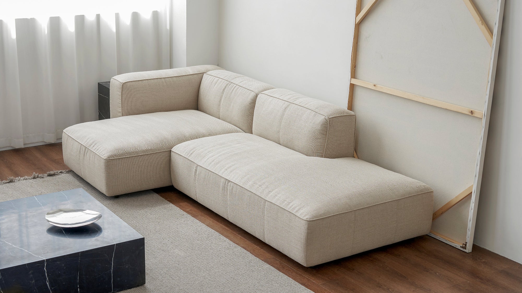 Beige sectional sofa in a living room with a coffee table and decorative items.