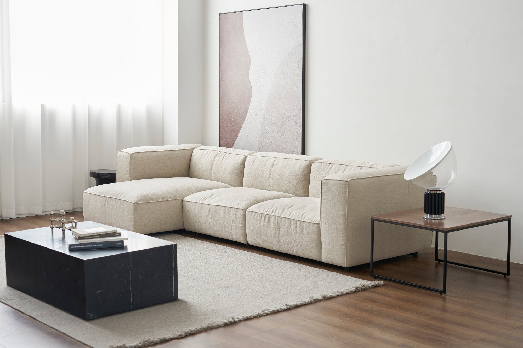 Beige sectional sofa in a modern living room with a coffee table and side table.
