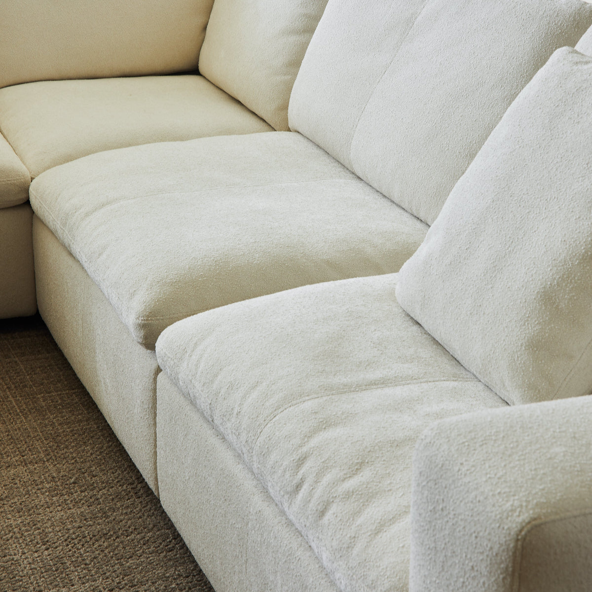 Beige sectional sofa in a living room setting with a neutral color scheme.