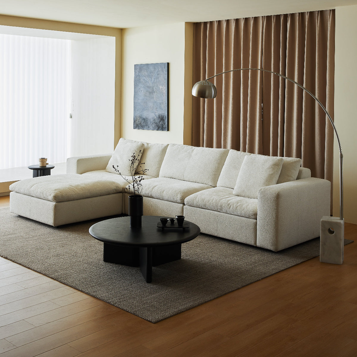 Modern living room with a white sectional sofa, black coffee table, and decorative elements.