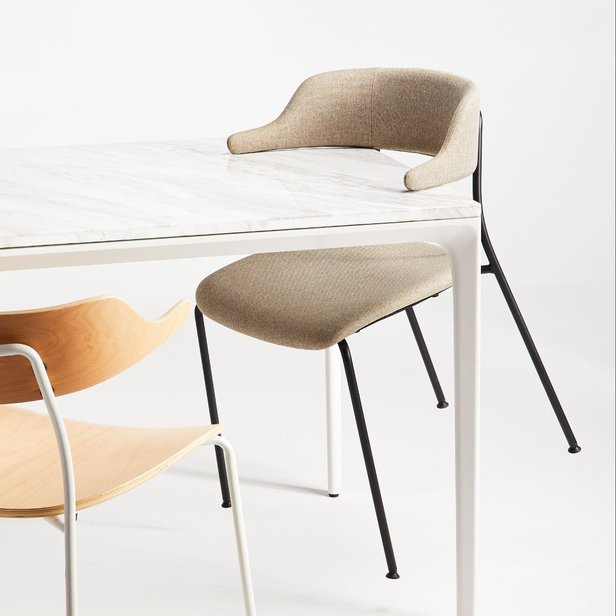 Two chairs, one with a wooden seat and the other with a fabric seat, on a white background.