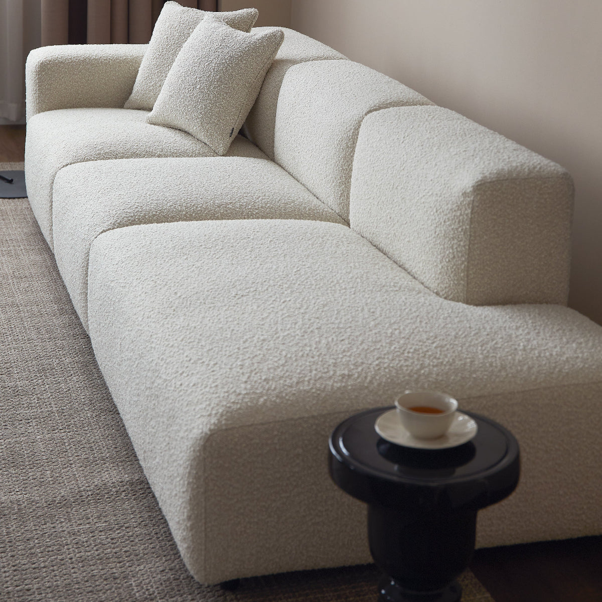 White sectional sofa in a room with a side table and lamp.