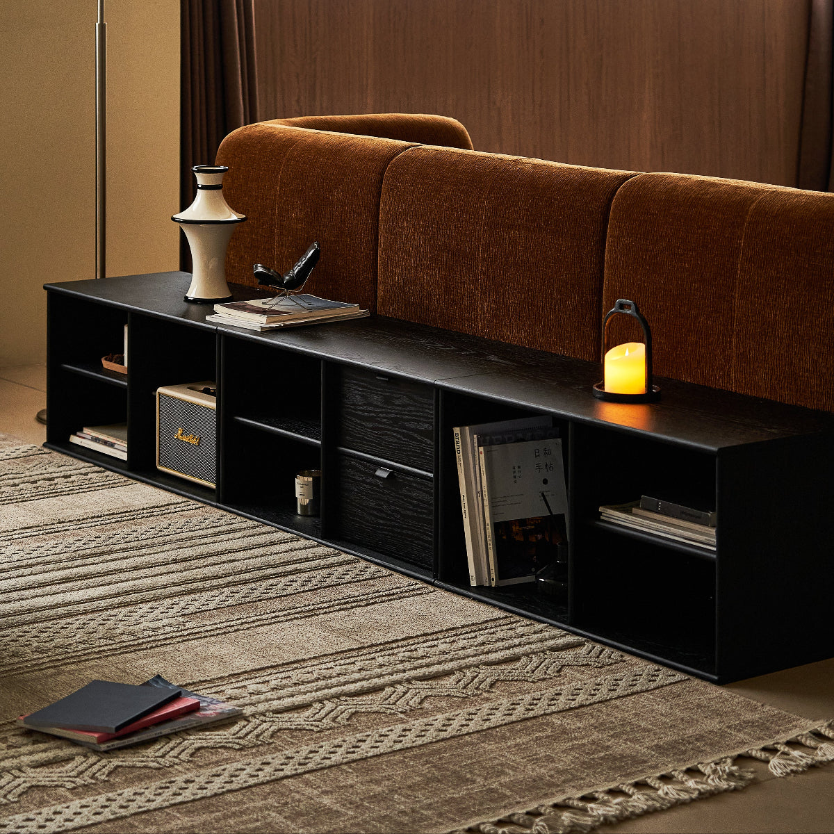 Modern living room with a brown sofa and black entertainment console.