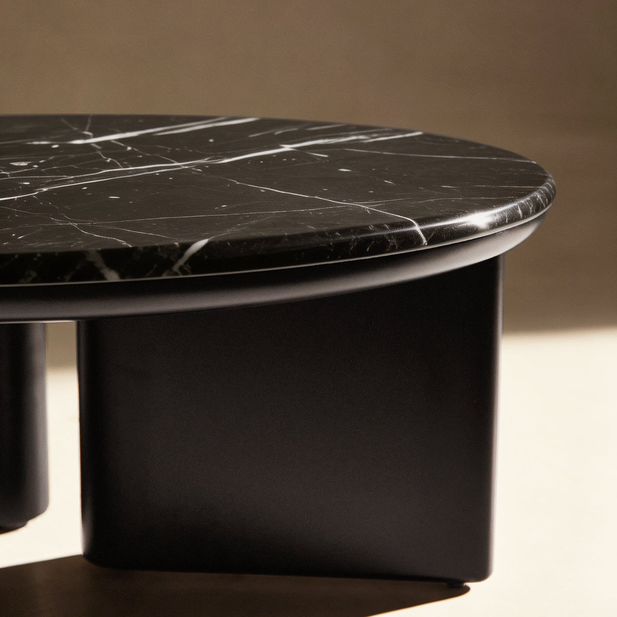 Black marble coffee table with a smooth surface on a beige background