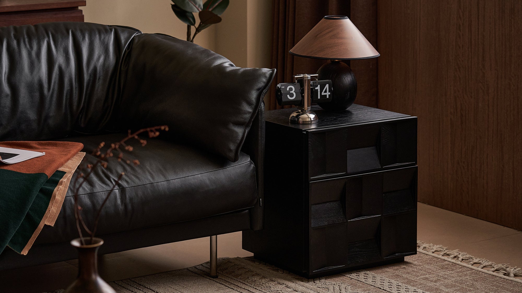 Black leather sofa with a side table in a living room setting