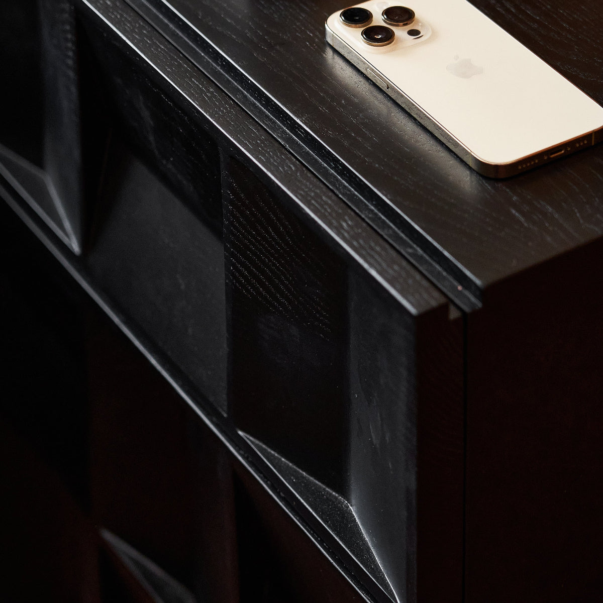 Smartphone on a dark wooden surface with a blurred magazine in the background