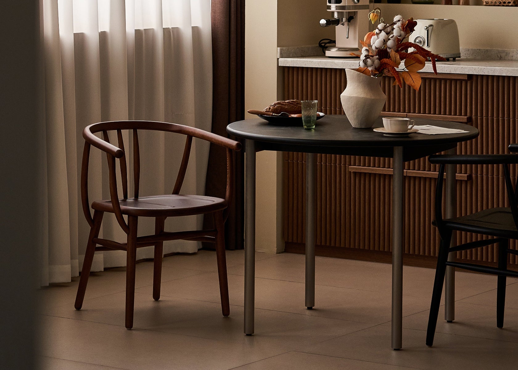 Small kitchen with a table, chairs, and various items on a countertop.