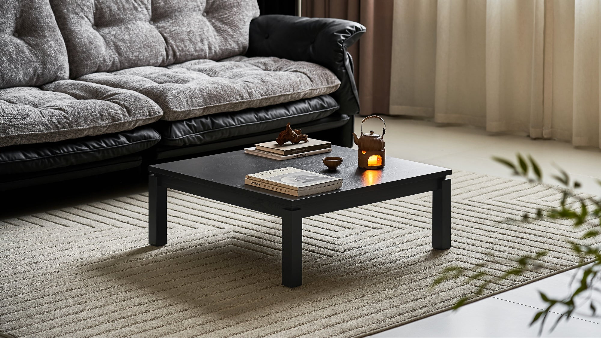 Gray sectional sofa with a black coffee table in a living room setting.