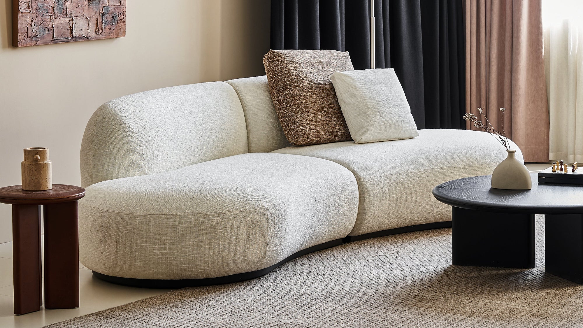 Modern living room with a white sofa, decorative pillows, and a lamp.