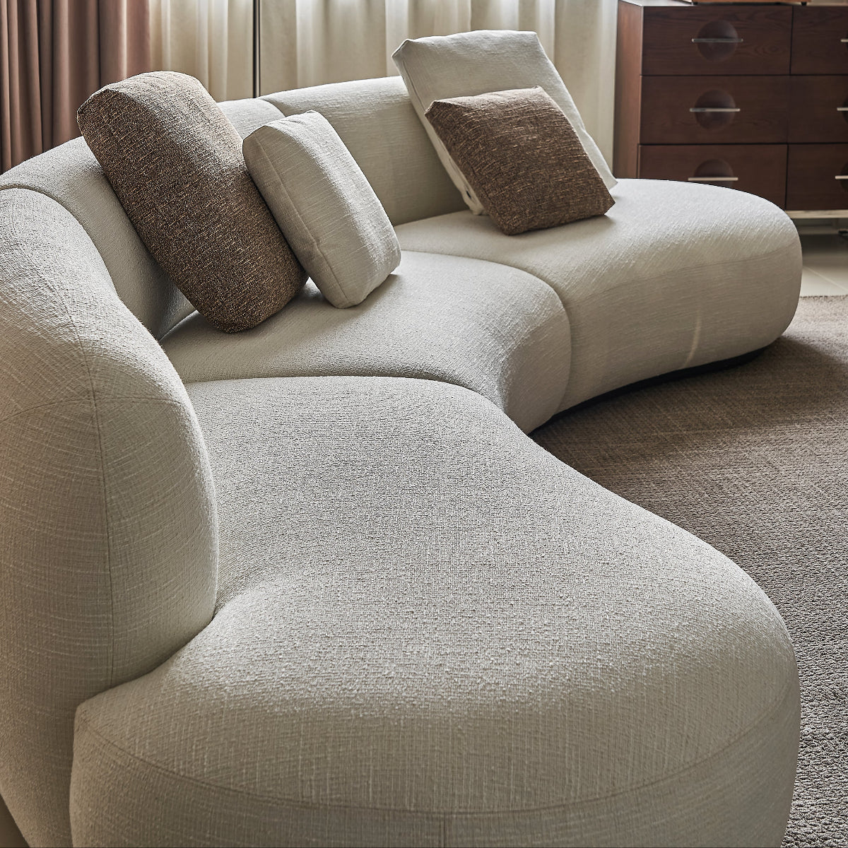 Beige sectional sofa with cushions in a living room setting