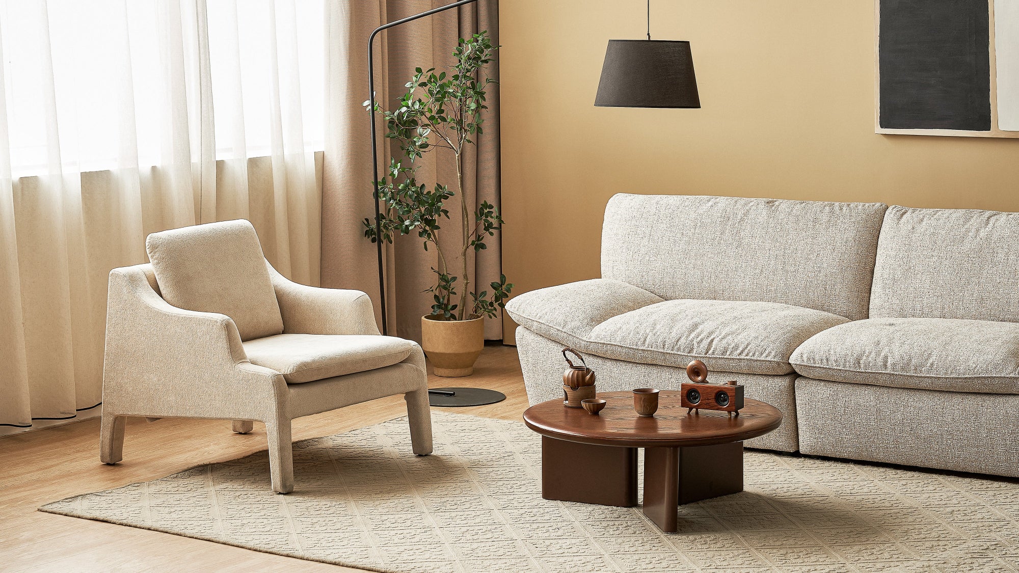 Modern living room with beige armchair, sofa, and coffee table.