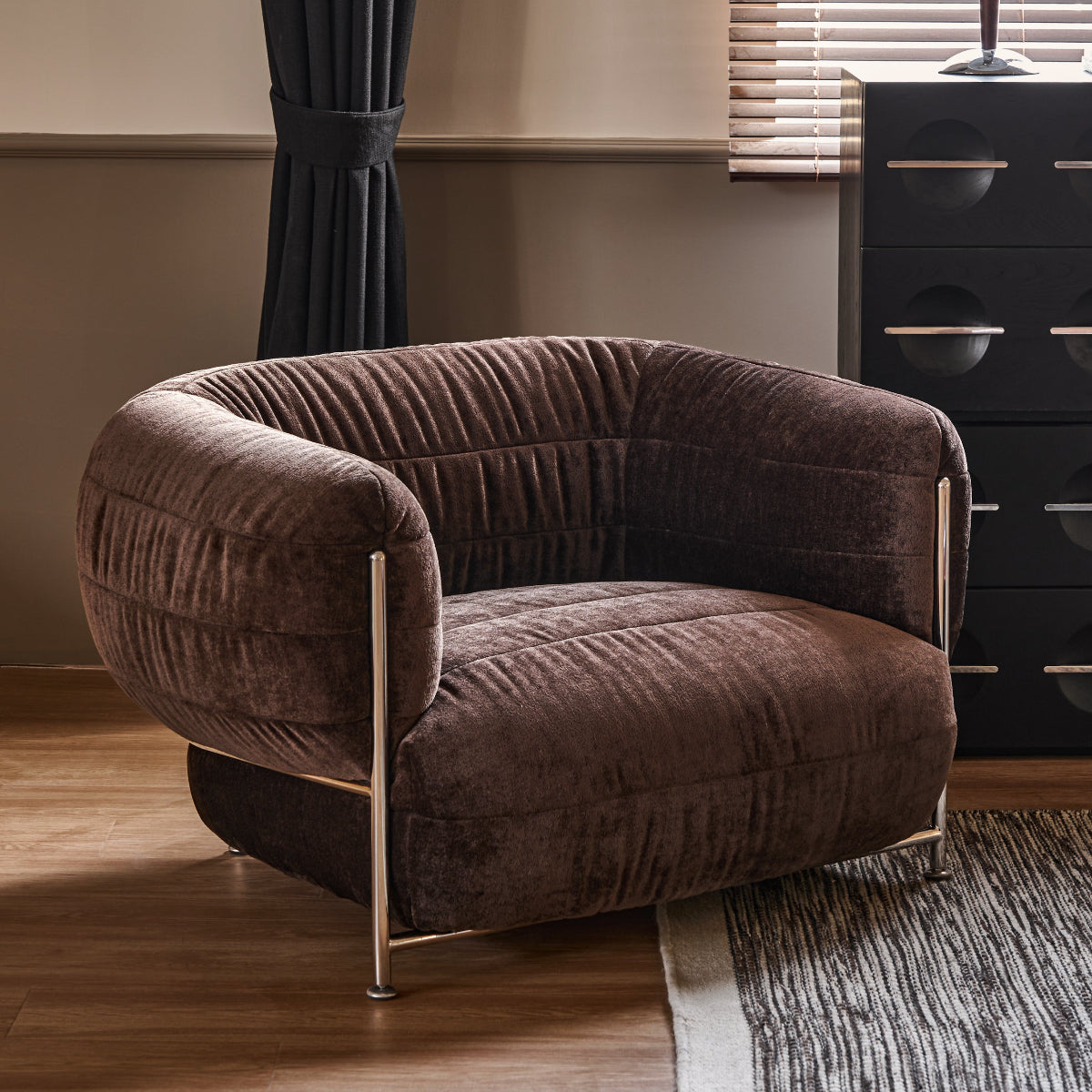 Brown armchair in a room with curtains and a lamp.