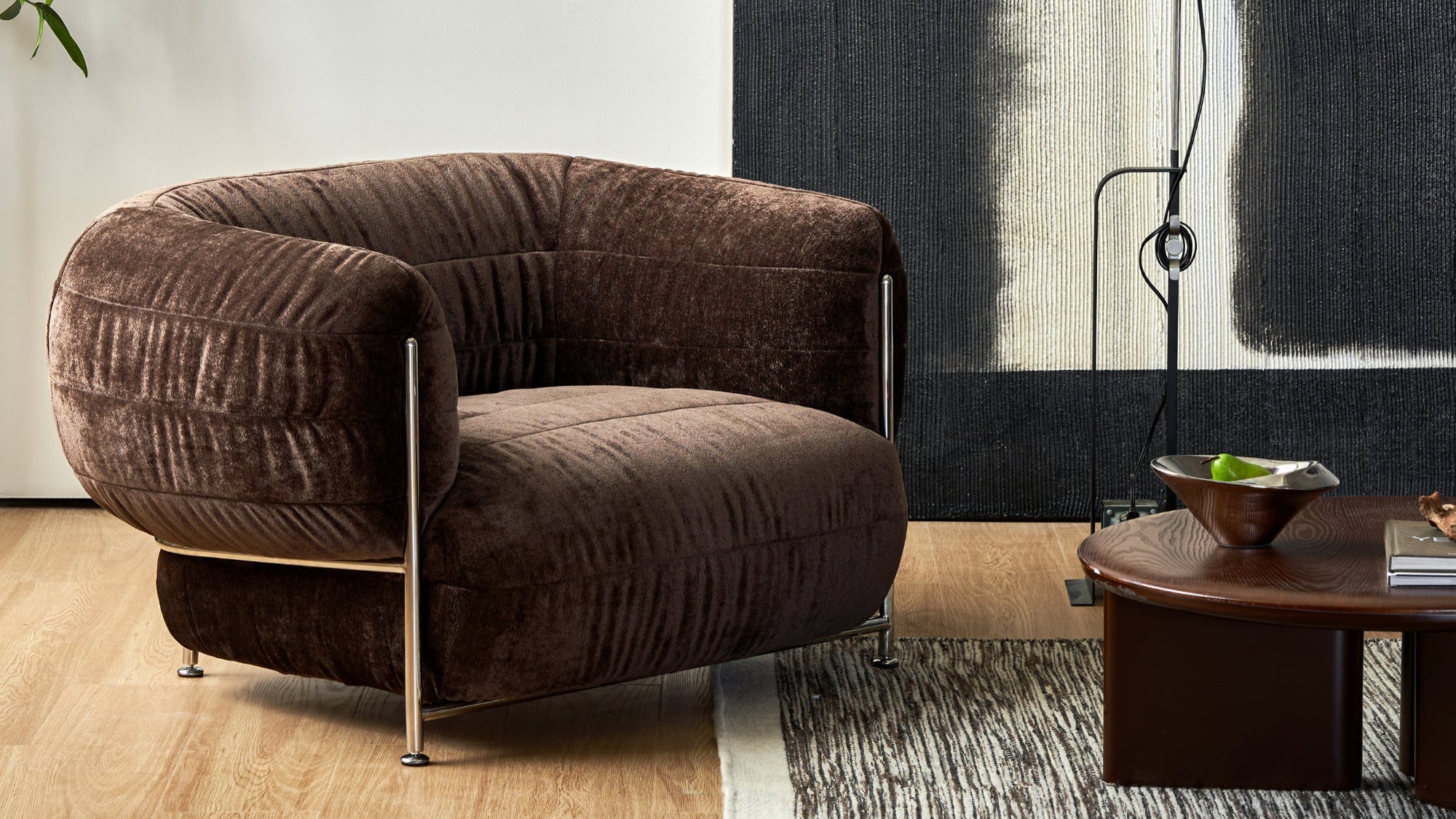 Brown armchair in a modern living room with abstract art and a plant.
