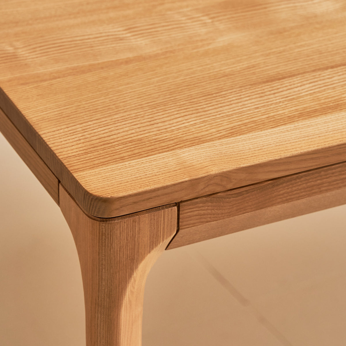 Close-up of a wooden table corner on a beige background