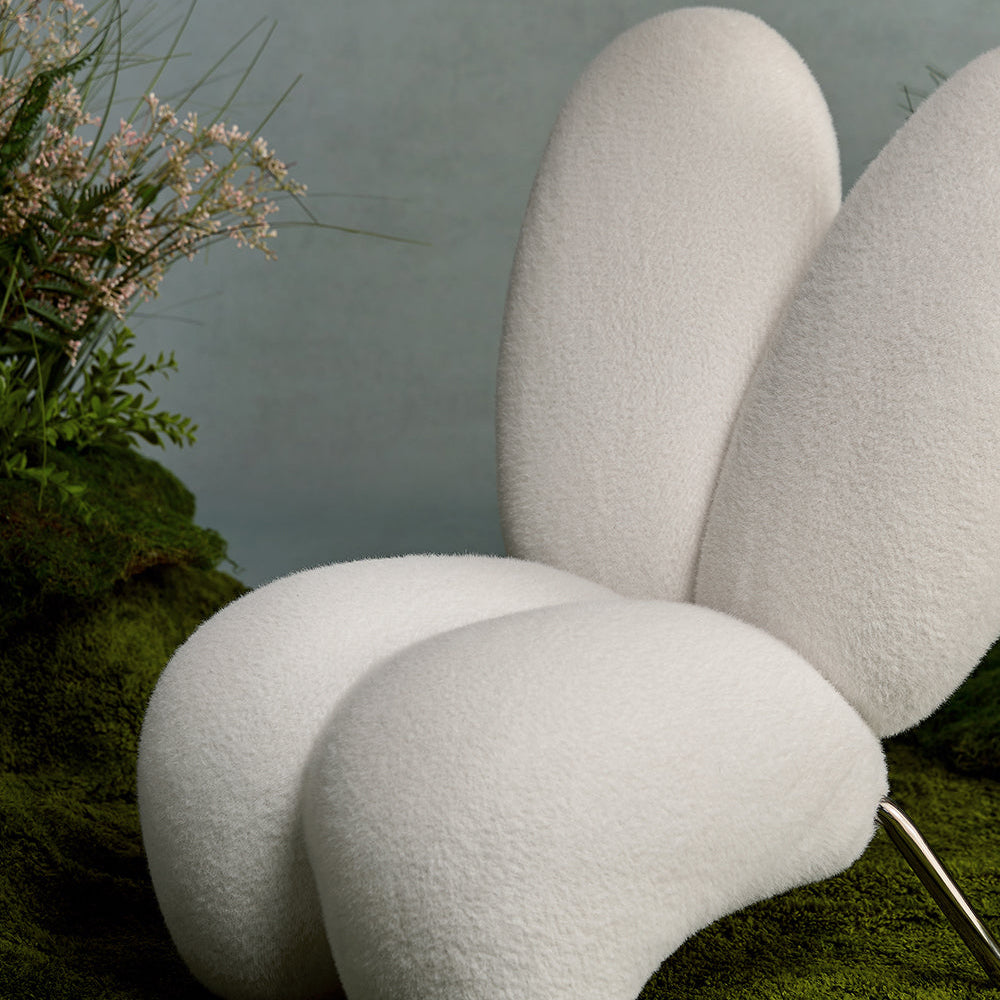 Modern white chair with organic design on a grassy surface
