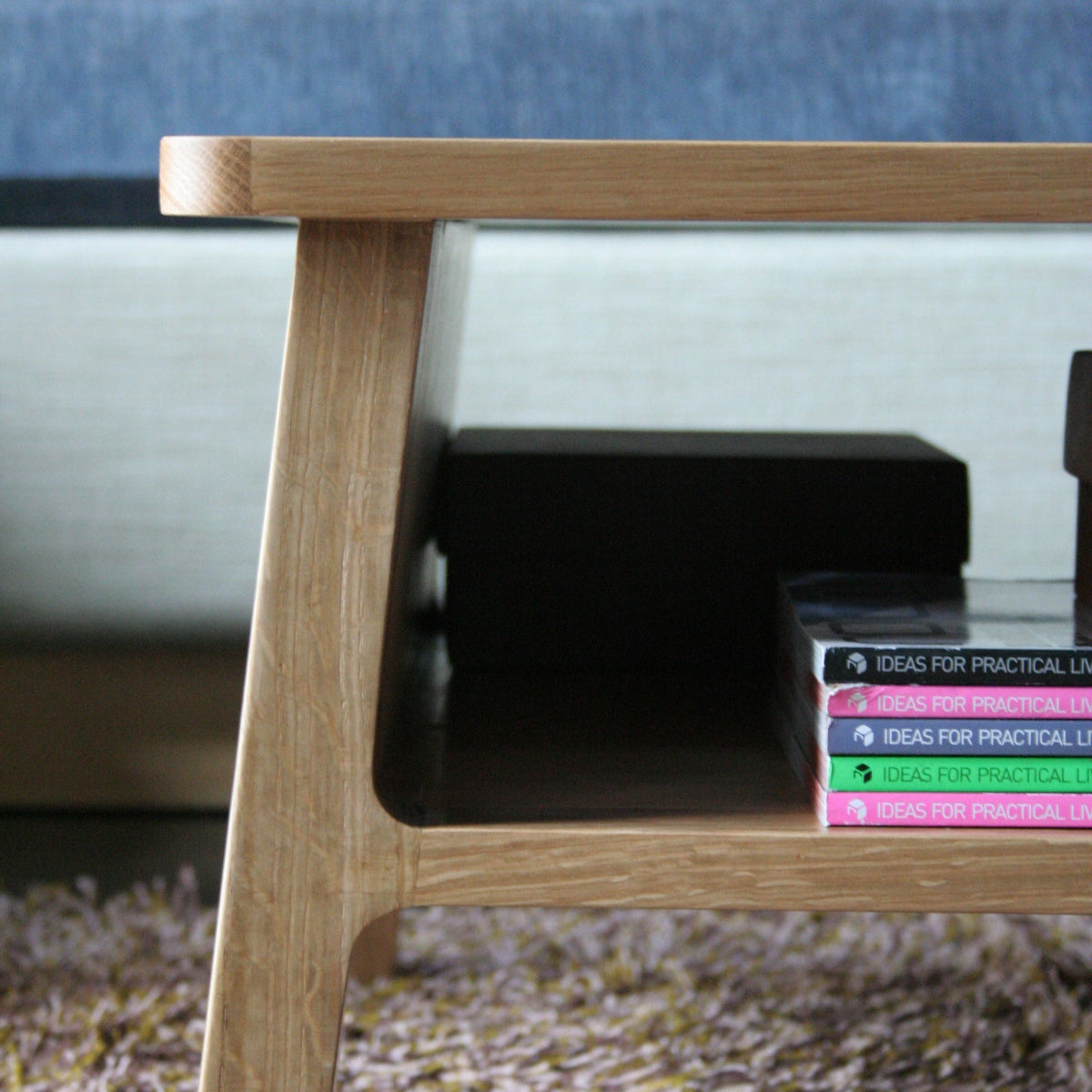 Wooden bookshelf with books against a textured wall