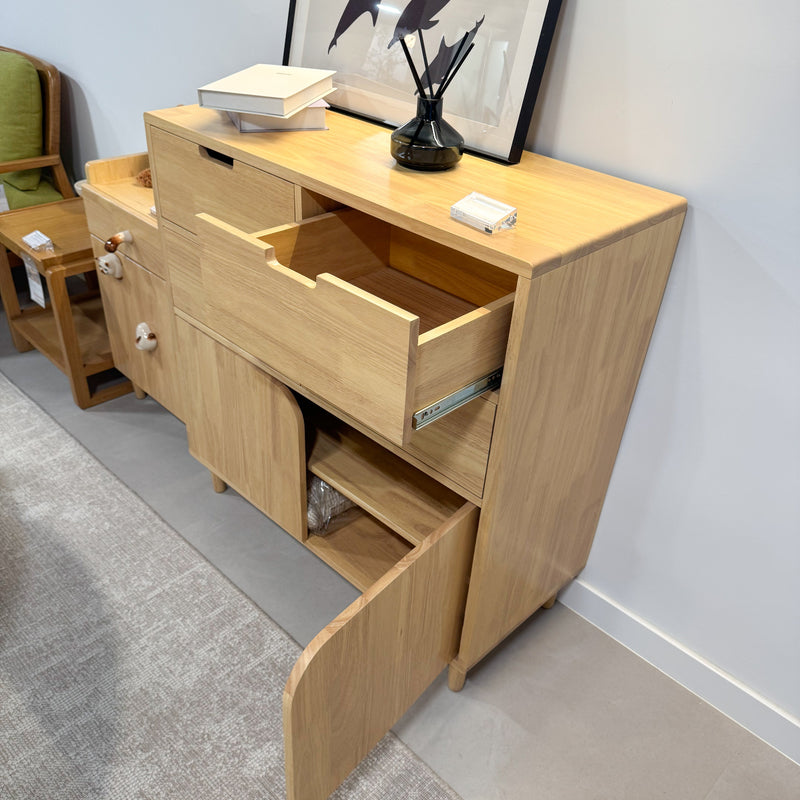 Wooden sideboard with open drawer in a room setting