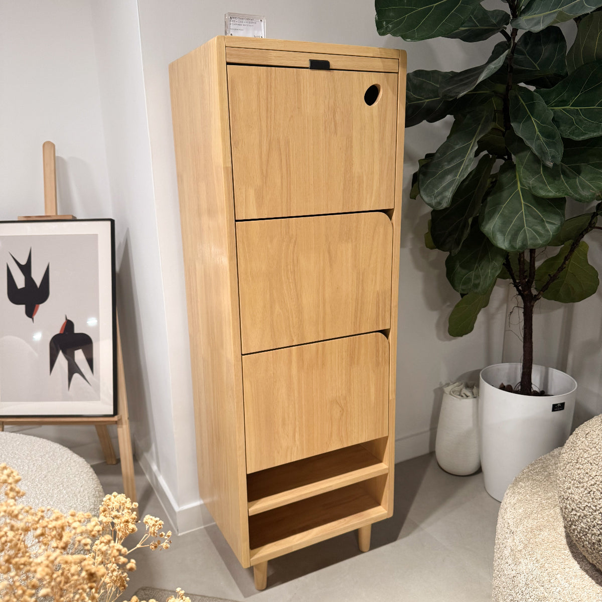 Wooden cabinet with drawers in a room with a plant and decorative items.