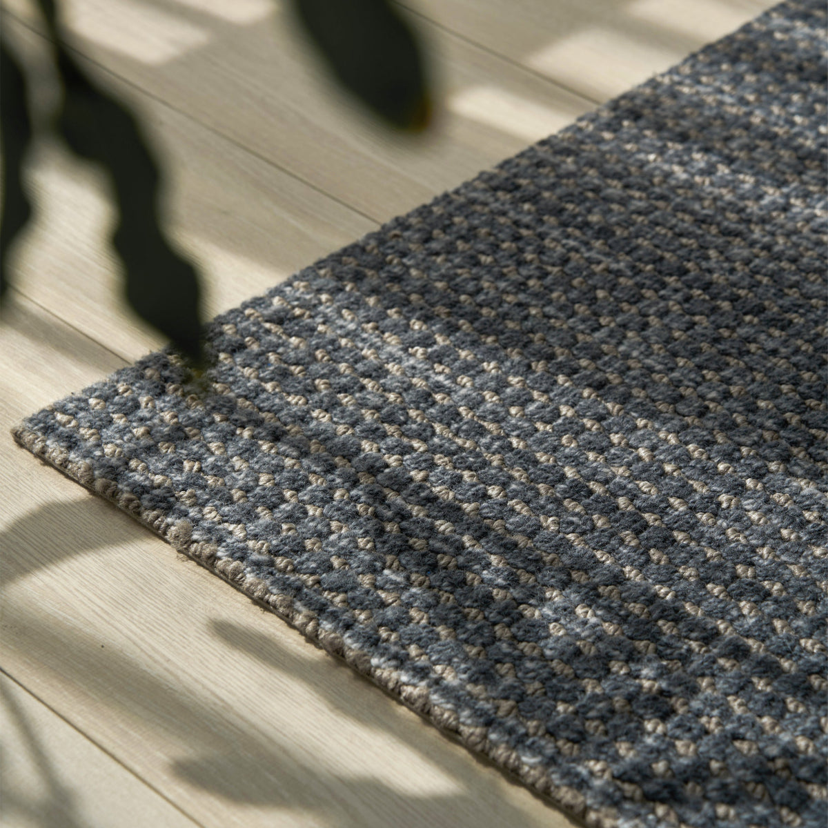 Gray textured rug on a light wooden floor