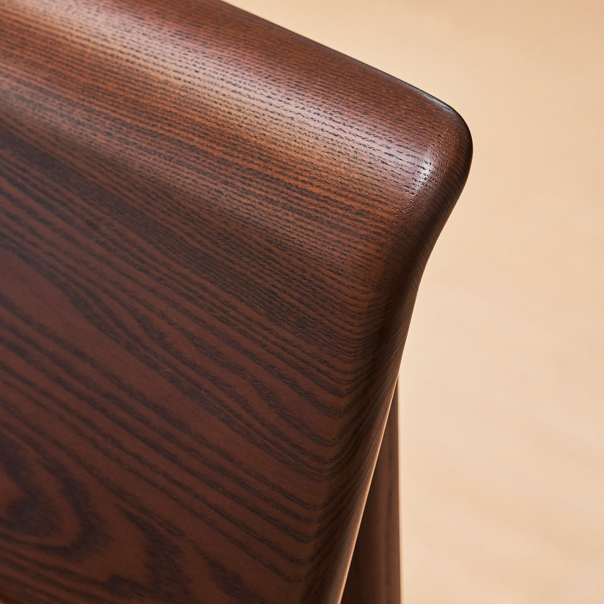 Close-up of a wooden chair backrest on a beige background