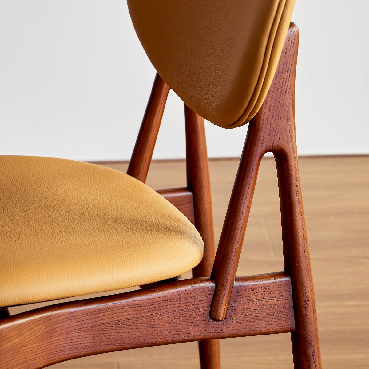 Wooden chair with yellow cushion on a wooden floor