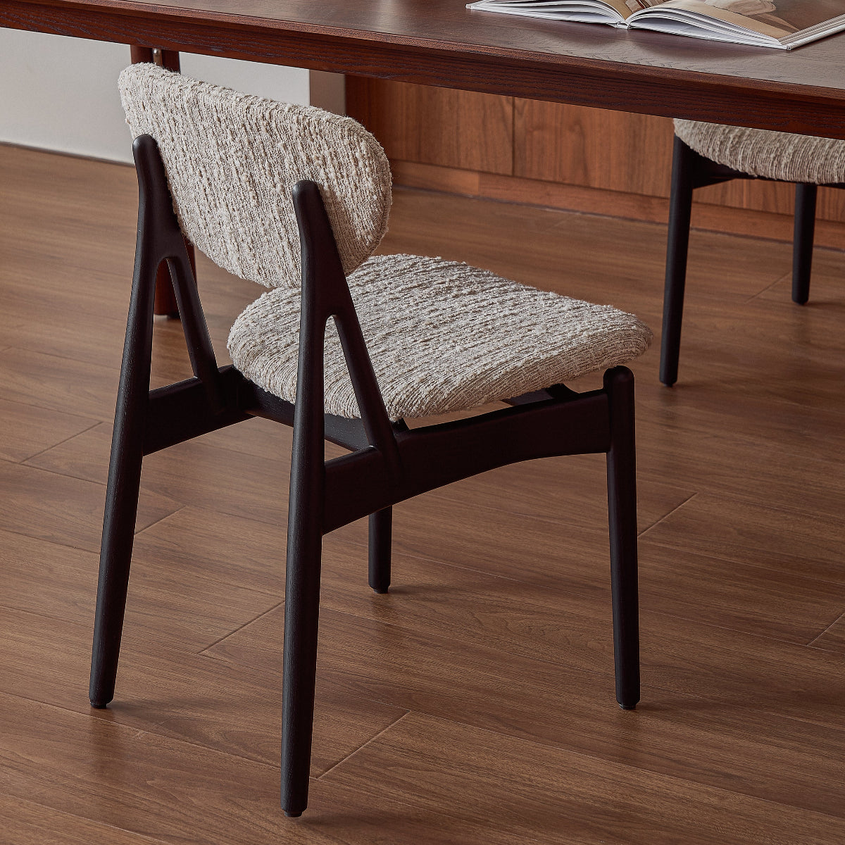 Dining table with chairs in a room with a kitchen counter in the background
