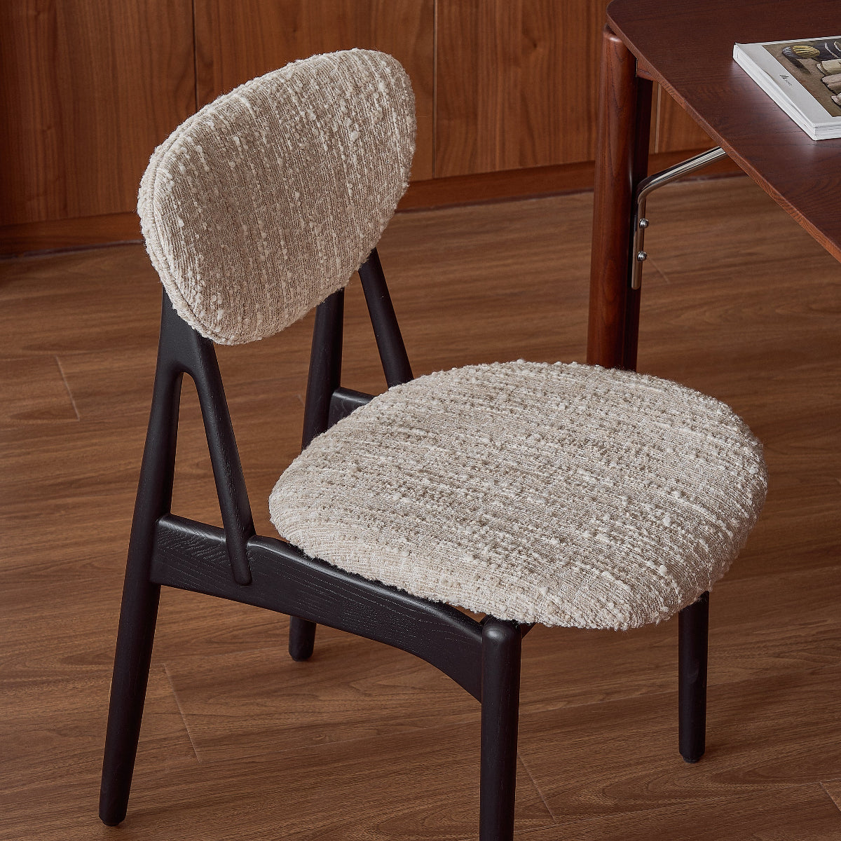 Chair with beige cushioned seat and backrest on a wooden floor.