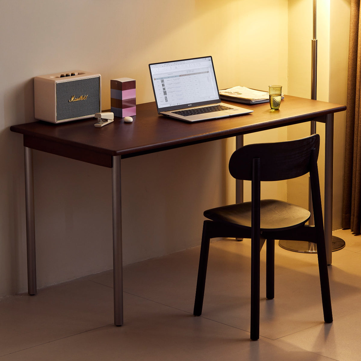 Modern home office setup with a desk, laptop, lamp, and decor.