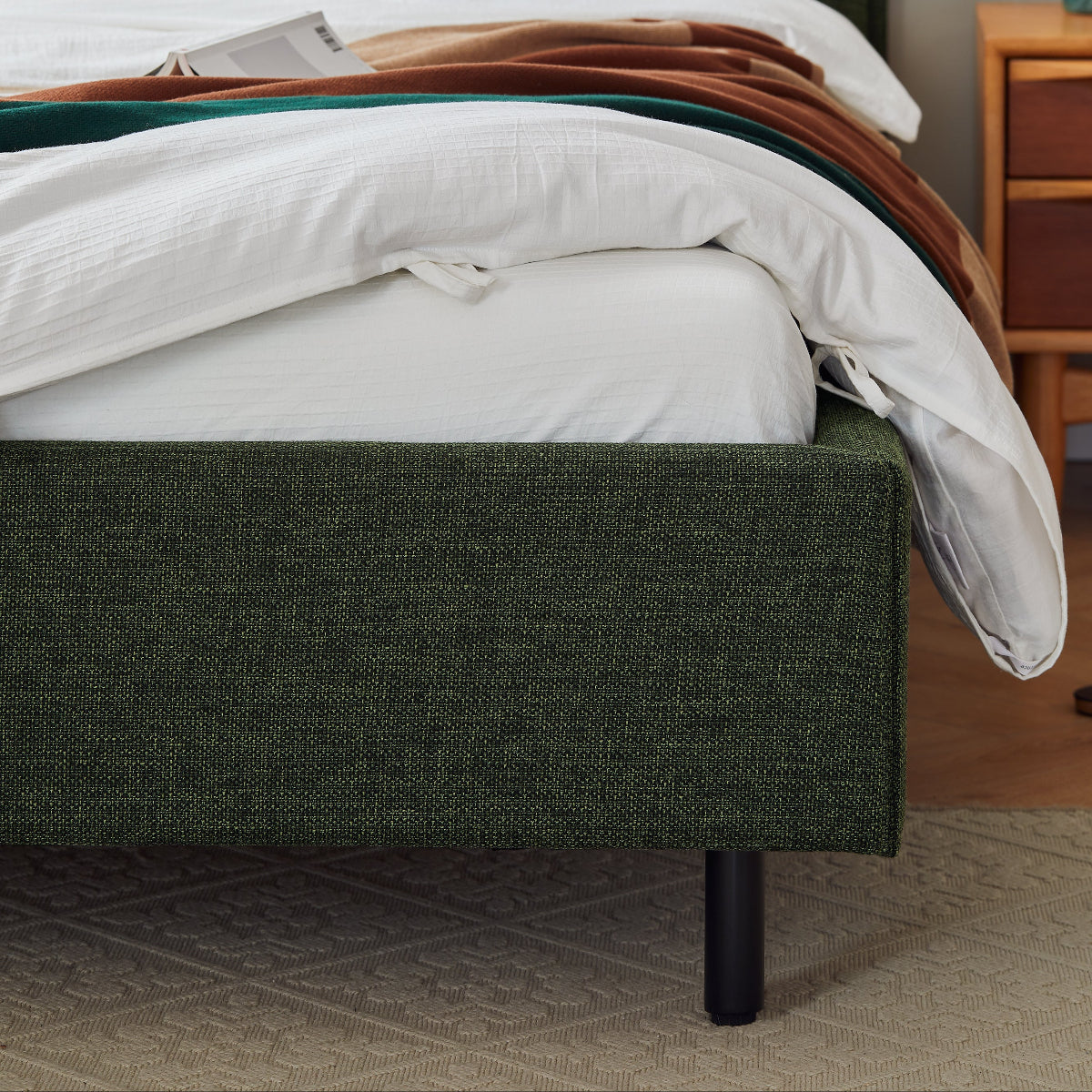 Green upholstered bed with white bedding in a bedroom setting