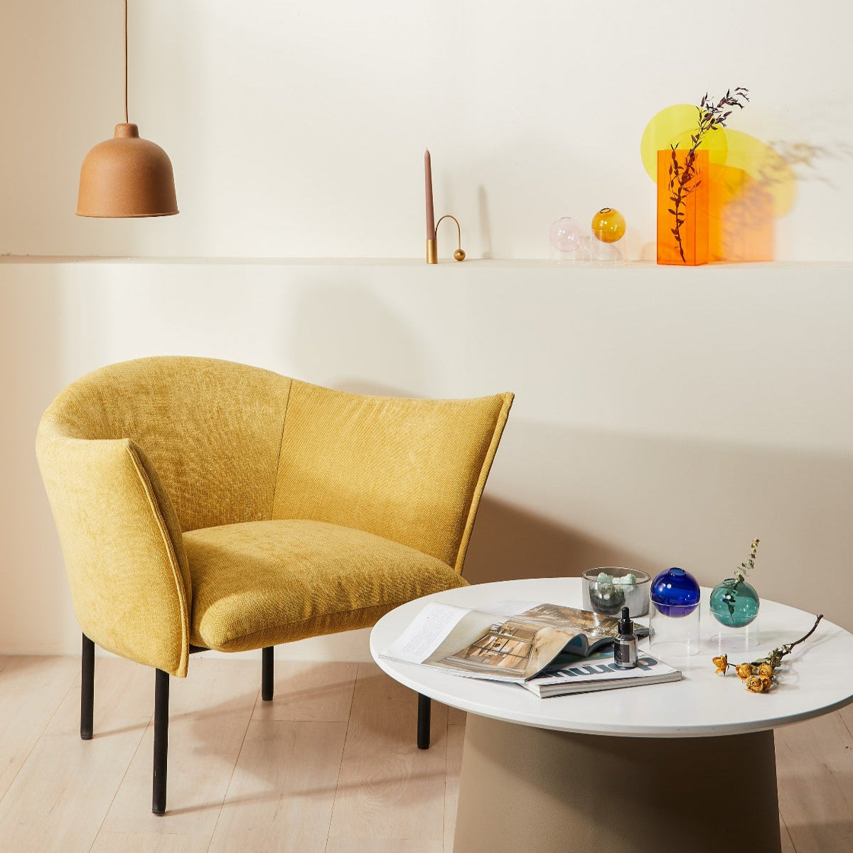 Yellow armchair in a modern living room with a small round table and decorative items.