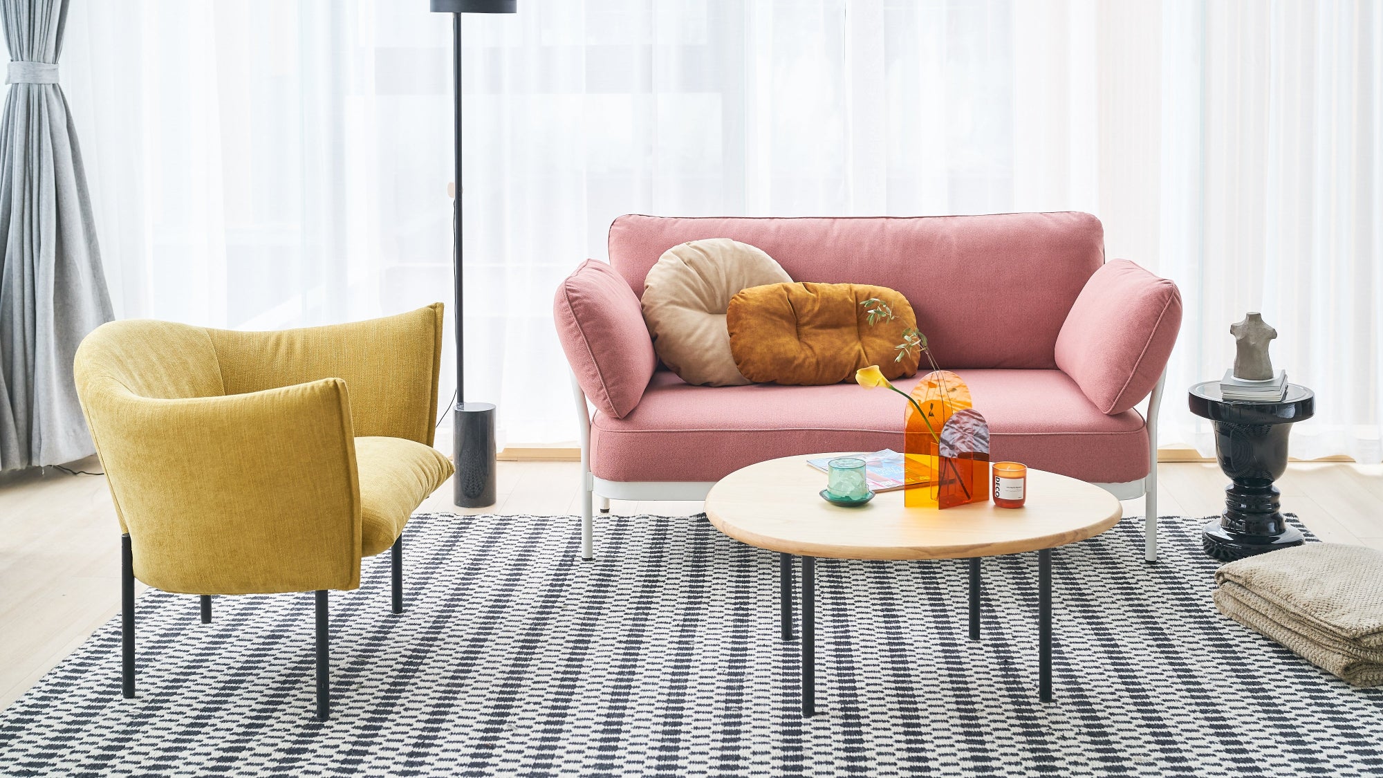 Modern living room with pink sofa, yellow armchair, and coffee table.