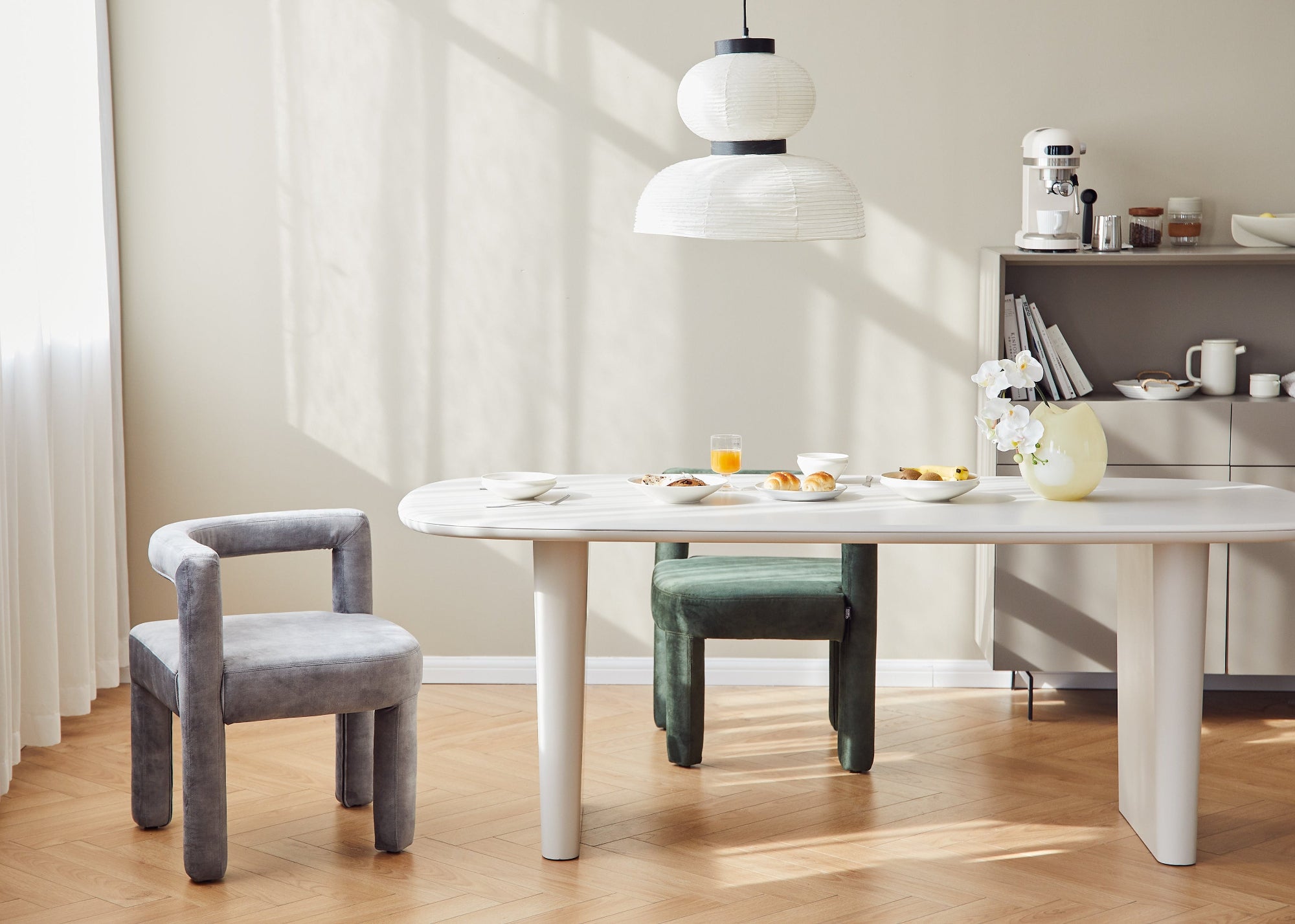 Dining area with a white table and chairs in a bright room.