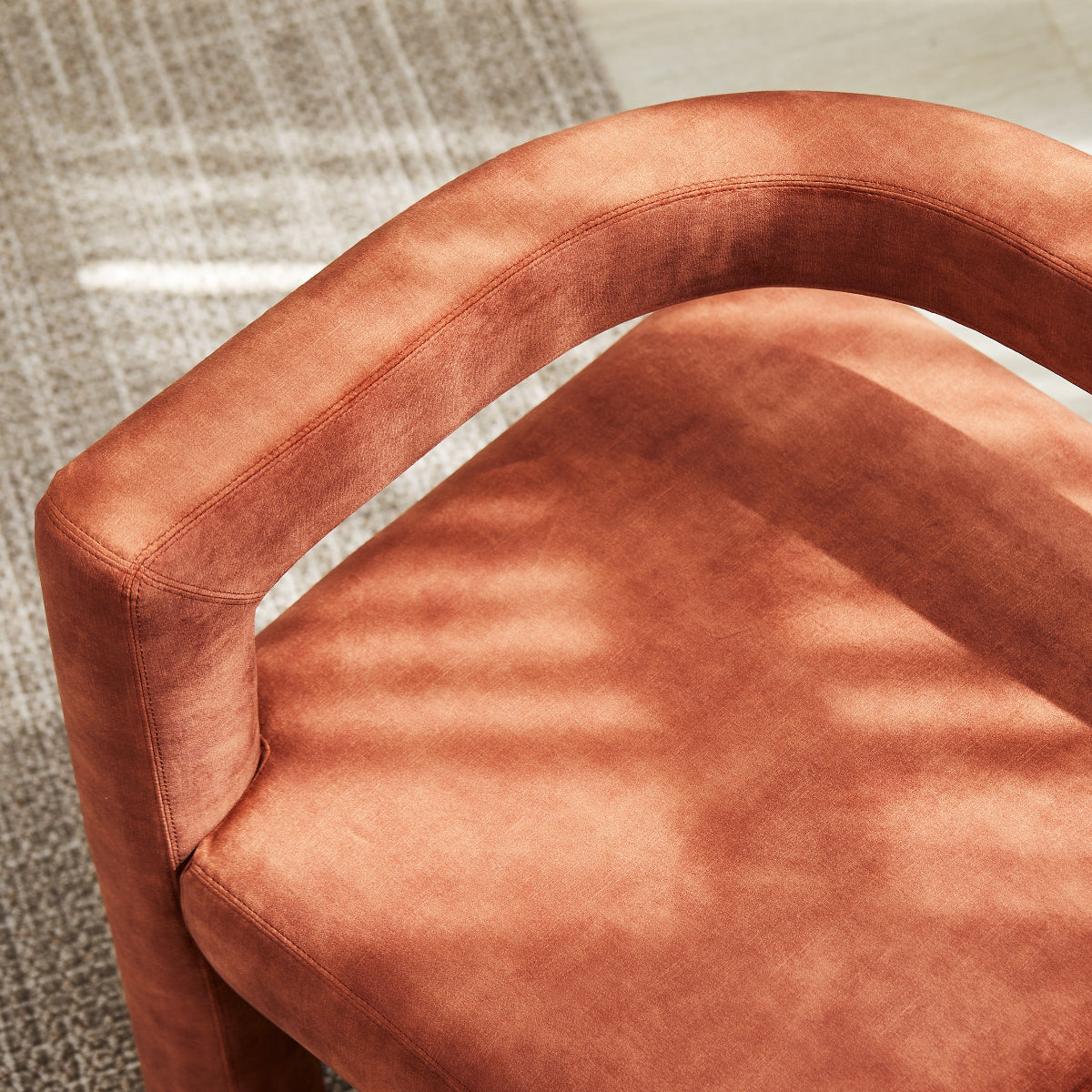 Brown chair with a textured surface on a patterned floor