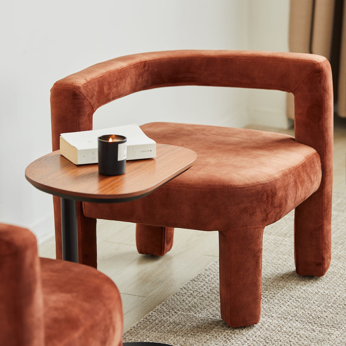 Brown upholstered chair with a small round table in a minimalistic room.