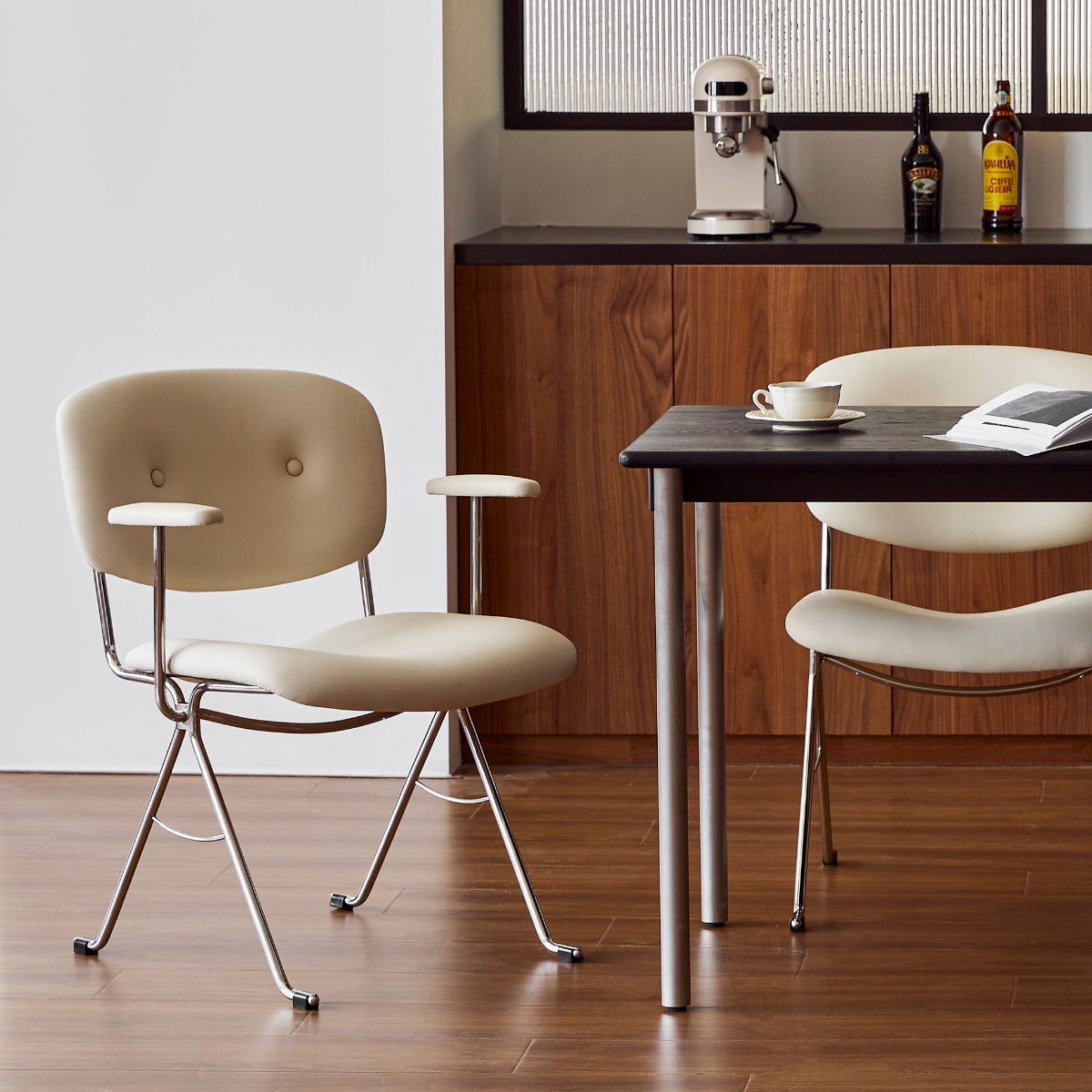 Modern dining area with a table and four chairs in a well-lit room.