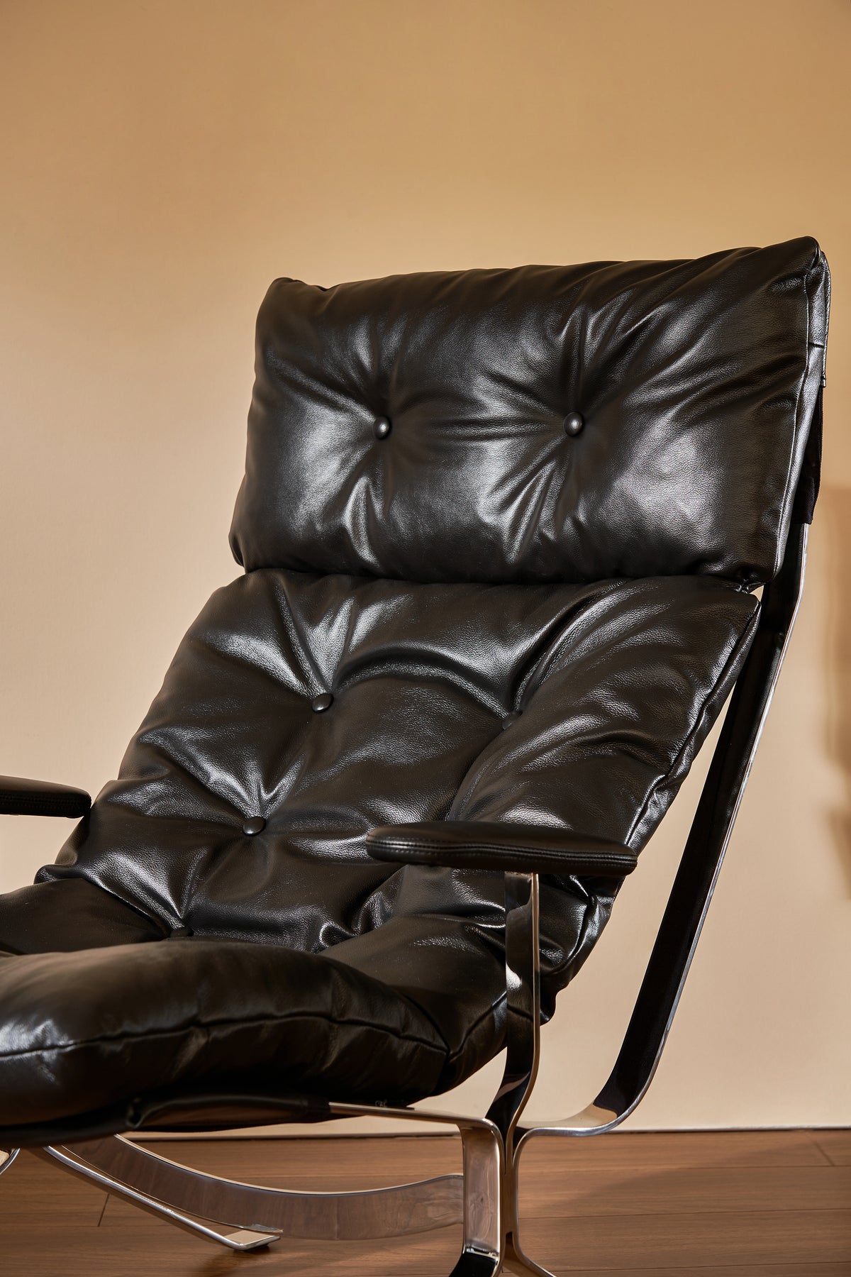 Black leather recliner chair on a beige background