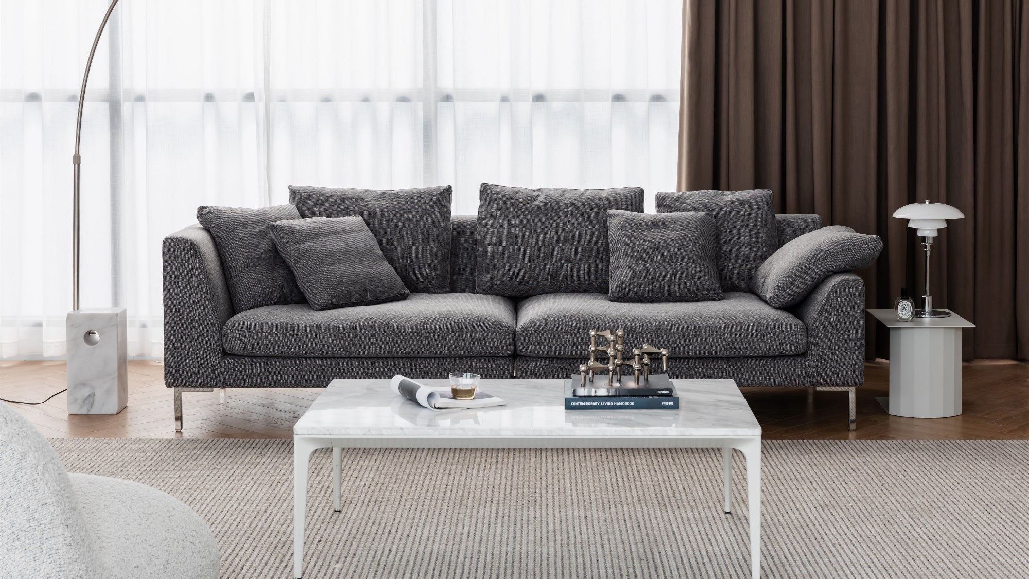 Gray sofa in a modern living room with a coffee table and decorative items.
