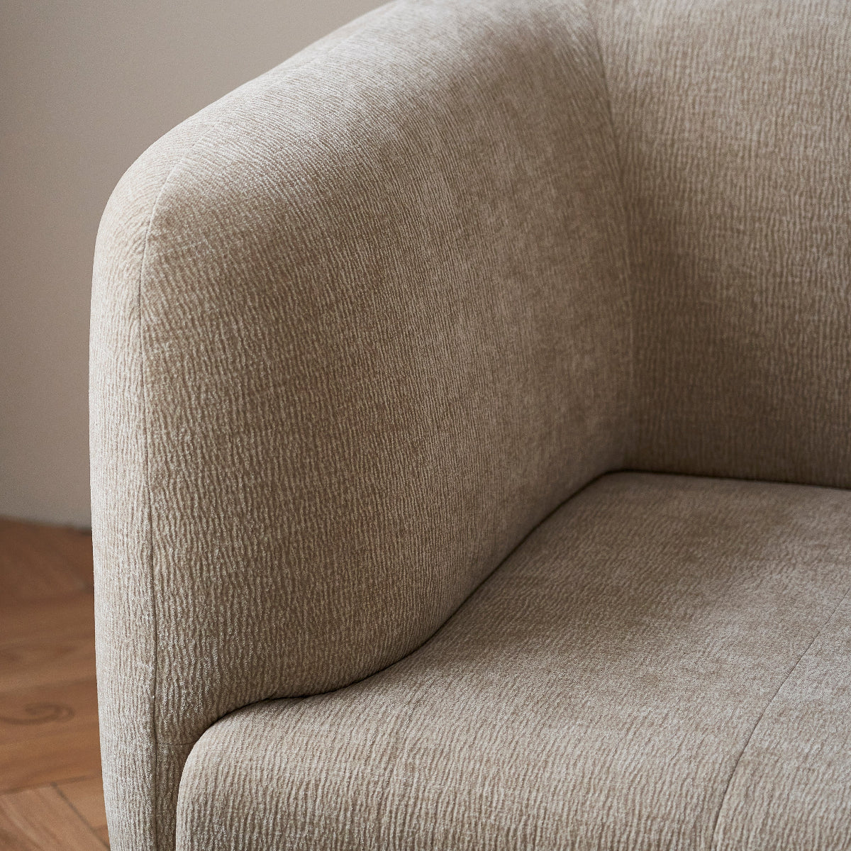 Close-up of a beige upholstered chair with a neutral background