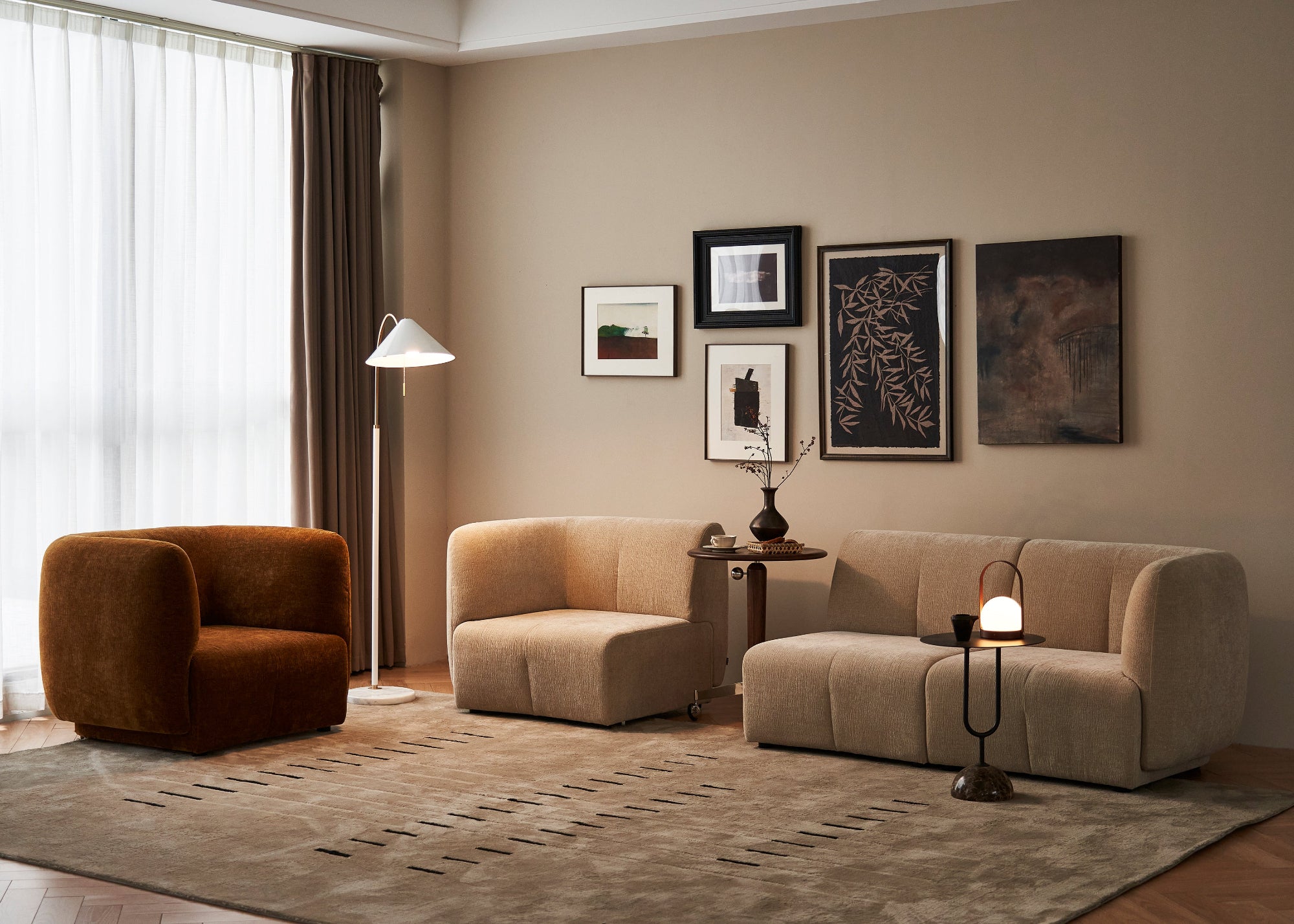 Modern living room with beige sofa, armchair, and decorative elements.