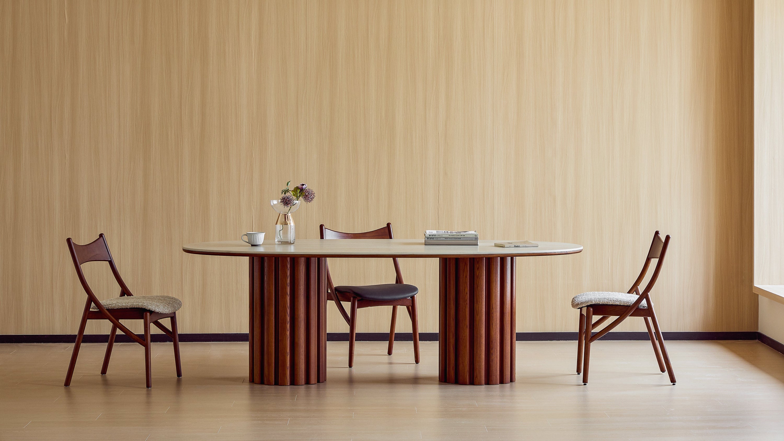 Dining table with four chairs against a beige striped wall.