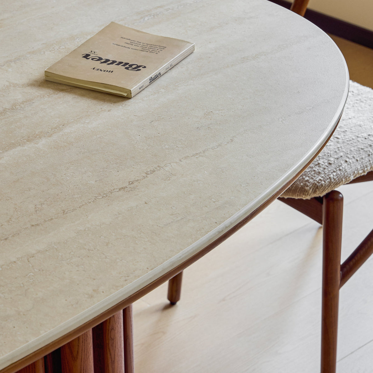 Round marble table with a book on top in a minimalistic room.