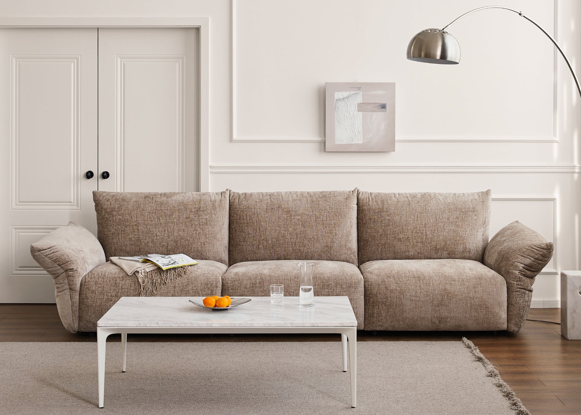 Beige sectional sofa in a living room with a coffee table and decor items.