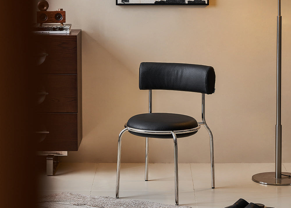 Modern interior with a black chair, wooden cabinet, and abstract painting on a beige wall.